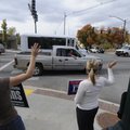TAKING IT TO THE STREETS - Leeann Collins, left, and Meredith Denton hold political signs Monday out...