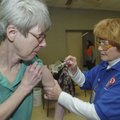  Connie Eby of Bentonville gets a vaccination Friday from Sue McDonald, a nurse with the Benton Coun...