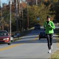 Halley Mallett of Searcy runs south along Old Wire Road on Saturday in Fayetteville. In order to bri...