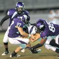 Rogers Heritage junior receiver Christian Wages, center, is tackled by Fayetteville senior linebacke...