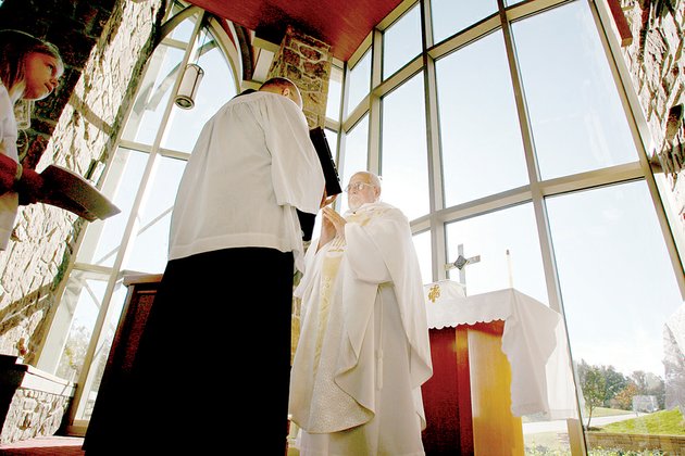 bobby-hall-priest-of-st-georges-anglican-church-in-rogers-reads-from-a-bible-held-by-lay-leader-bob-stockand-during-mass-on-sunday-the-congregation-which-is-affiliated-with-the-anglican-church-in-america-is-seeking-entrance-into-the-roman-catholic-church