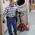 Tommy Easterling, left, and Leeroy Gonzalez roll part of a heating boiler Monday to an elevator on t...