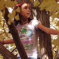 Abbi Wike, 9, sits with a bird’s eye view Tuesday from a ginkgo tree along South Main Street in down...