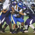 North Little Rock running back Altee Tenpenny, center, is tackled by Fayetteville junior defensive e...