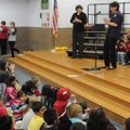 Rogers School District Assistant Superintendent Virginia Abernathy, right, applauds students Monday ...