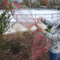 Teresa Brown with B LaRue in Bentonville helps decorate the community Christmas tree on Wednesday at...