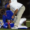 Bryant running back Karon Dismuke is checked for a wrist injury on Oct. 15 by athletic trainer Chris...