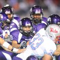 Fayetteville junior linebacker Chaz Miller, center, and other members of the Purple’Dogs defense ta...