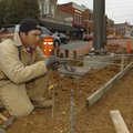  Fernando Bautista works Thursday at Third and Walnut streets in downtown Rogers. Improvement to the...