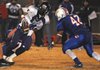  Fayetteville’s Alex Brignoni is tackled by a pair of West Memphis defenders Friday during their second-round game in the Class 7A State Playoffs at West Memphis.
