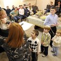 Dobi Greisman cuts a lock of her son’s hair while other children watch.
