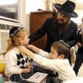 Under the watchful eye of his father, Rabbi Mendel Greisman, Verel Greisman, 5, cut a lock of Mordec...