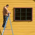  Jason Northan takes advantage of the warm weather Friday and opens a pail of paint before putting a...