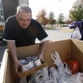 Roger Price of Fayetteville, operations manager for Cumulus Broadcasting, arranges canned goods with...