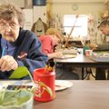 Jane Hughes, left, a resident of Butterfield Trail Village in Fayetteville, paints a watercolor of a...