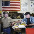 Charles Miller, left, hands a plate of food Thursday to Mike Hawkins to box up and send out for deli...