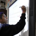 Francisco Barrientos, 16, writes a question to an answer Nov. 17 on a Smart Board in his U.S. histor...