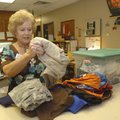 Linda Fragassi, secretary at Grace Hill Elementary School in Rogers, shows some of the clothes given...