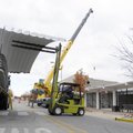 Scott Elliott with Multi-Craft Contractors uses a forklift to place a section of the metal roof remo...