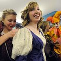 MADRIGAL FEAST Addyson Christopherson, 16, left, helps Claire Thompson, 17, adjust her early Renaiss...