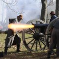  cannoneers portraying a Confederate unit fire their weapon during the Prairie Grove Battlefield Sta...