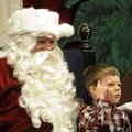  William Byford, 4, thinks about what he wants for Christmas as he sits on Santa Claus' lap Saturday...
