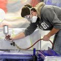  Siloam Springs high school student Blake Grigg paints a golf card during Northwest Technical Instit...