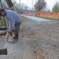 WILSON TRAIL FACELIFT - Chris Stanphill of Rogers, left, uses a concrete saw Thursday to prepare the...