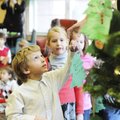 DECORATING TREE - Nicholas Baskin looks for a place on the Christmas tree to hang his ornament Thurs...