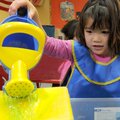 POLAR BEAR CLASS Wearing the required smock, Annabelle Mericle, 5, sprinkles soapy water into a cont...