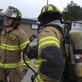 SCHOOL EVACUATION Rogers firefighters John Fox, left, and Chance Murray wait Friday outside Grace Hi...