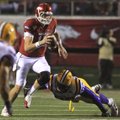 Ryan Mallett slips out of the grasp of LSU defender Drake Nedis in the fourth quarter of the Razorba...