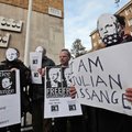 Supporters of WikiLeaks founder Julian Assange, some wearing masks depicting him and holding placard...