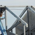 A worker welds a metal roof at the new Happy Hollow Elementary School.