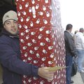 Ryan Petrancosta balances four Christmas packages while delivering them Friday during the Sharing an...
