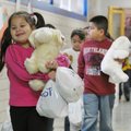 CHRISTMAS CARING Joanna Pacheco, a kindergartner at Jones Elementary School, hugs a stuffed toy Frid...