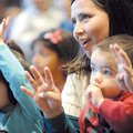 ATTENTIVE AUDIENCE Clarisa Pierce of Fayetteville sings and laughs Saturday with her son, Sebastian,...