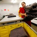 Angela McGarrah (front) and Jennifer Ward fold laundry Friday after removing items from dryers at th...