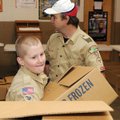 Matthew Kemp, 11, a Bentonville Boy Scout from Pack 52, helps stack one of 600 boxes of food for Chr...