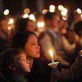 Erin Hightower of Conway, center, sings while holding a candle with her nephew, Benjamin Harrigan, 6...