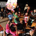 Children laugh while collecting candy from a pinata during a Las Posadas celebration Tuesday at a ho...