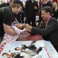 Actor Will Ferrell, right, signs a baby blanket for Eli Raymond and his 1-month old daughter Izabell...