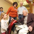 Mikayla Cathcart, 4, left, explains that she is 4 years old to her great-grandfather, Bob Hughey, ri...