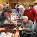  Leo Kleinschmidt gets a serving of cranberry sauce for his Christmas dinner from volunteer Dan Hart...