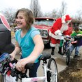  ayme Lowe, 9, left, wheels her new bicycle to her house Friday after Dan Puitt, center, delivered t...