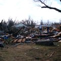 Workers clamber over rubble piles that once were homes on the west side of Arkansas Highway 59 in Ci...