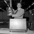 Astronaut Richard H. Truly holds a plaque displaying a moon rock and a small Arkansas flag that he p...