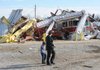 Residents walk past the Lincoln-Cincinnati fire station after it was destroyed on Friday, Dec. 31, 2010, in Cincinnati. A tornado ripped through the small community around 6:00 a.m., causing at least three fatalities.