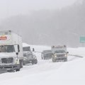 Vehicles pass a couple of semi trucks stuck in the snow Wednesday on U.S. 71 in Bentonville.