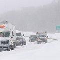 Vehicles pass a couple of semi trucks stuck in the snow Wednesday on U.S. 71 in Bentonville. <a href...